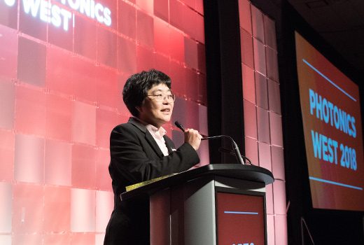 A presenter speaks in front of an audience